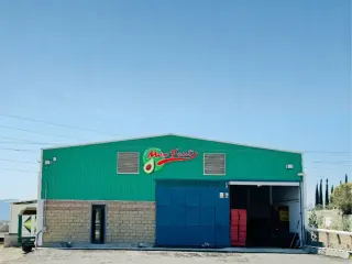 Fachada de la empacadora Mexfrut con el portón de acceso a planta abierto